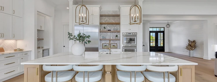 Bright kitchen with quartz island, oak cabinetry, brass pendants, and herringbone backsplash