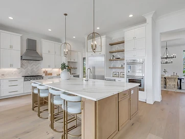 Full kitchen with white shaker cabinets, steel range hood, herringbone backsplash, and oak island
