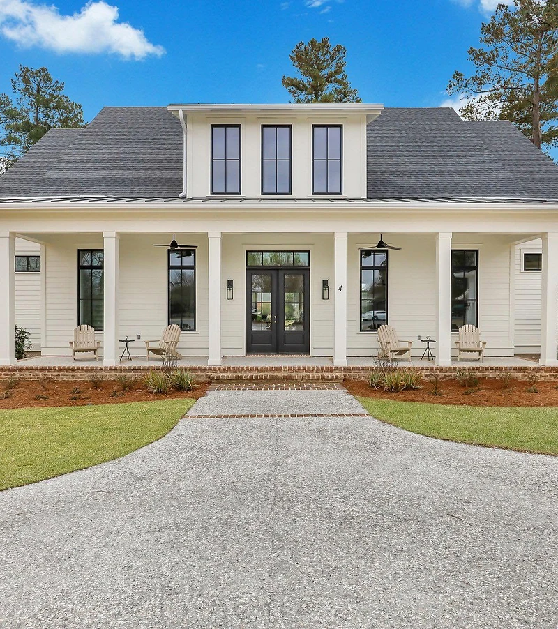 Dark shingle roof and a metal porch roof on a white two-story home