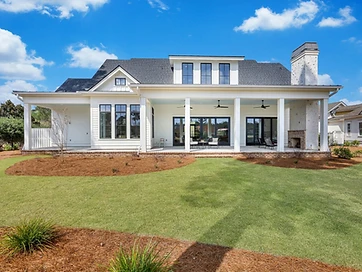 Rear elevation of a custom home with covered porch, ceiling fans, and outdoor fireplace
