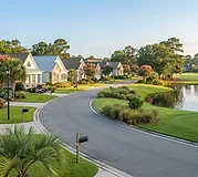 Tidy single-story homes along a curved street in a coastal SC active-adult community