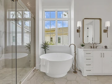 Primary bath with freestanding soaking tub, brass fixtures, and hexagon marble tile floor