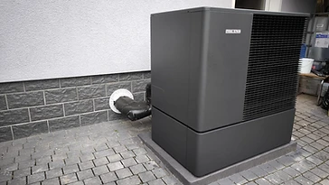 Stiebel Eltron Wärmepumpen-Außeneinheit auf Fundament am Wohnhaus