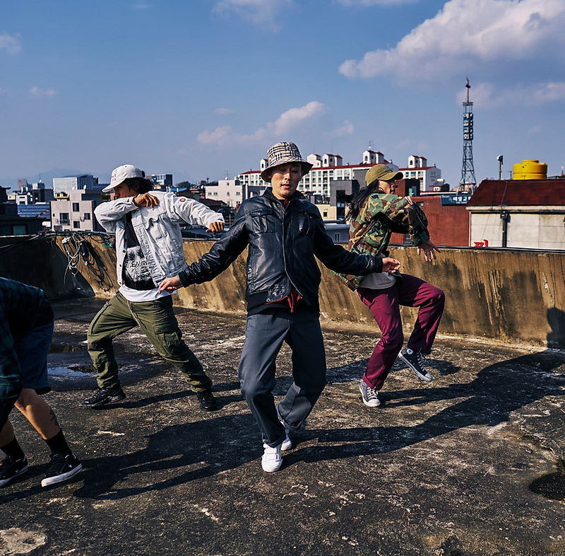 Group of streetwear dancers on a rooftop in dynamic motion