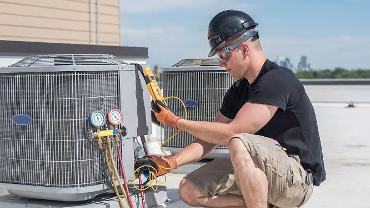 HVAC technician servicing an outdoor air conditioning unit