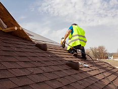 Roofer installing shingles on a residential roof