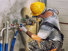 Plumber repairing pipes under a kitchen sink