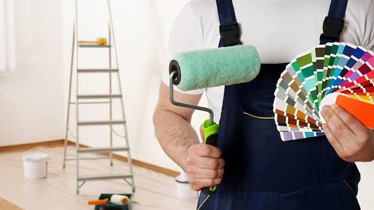 Painter rolling paint on an exterior wall