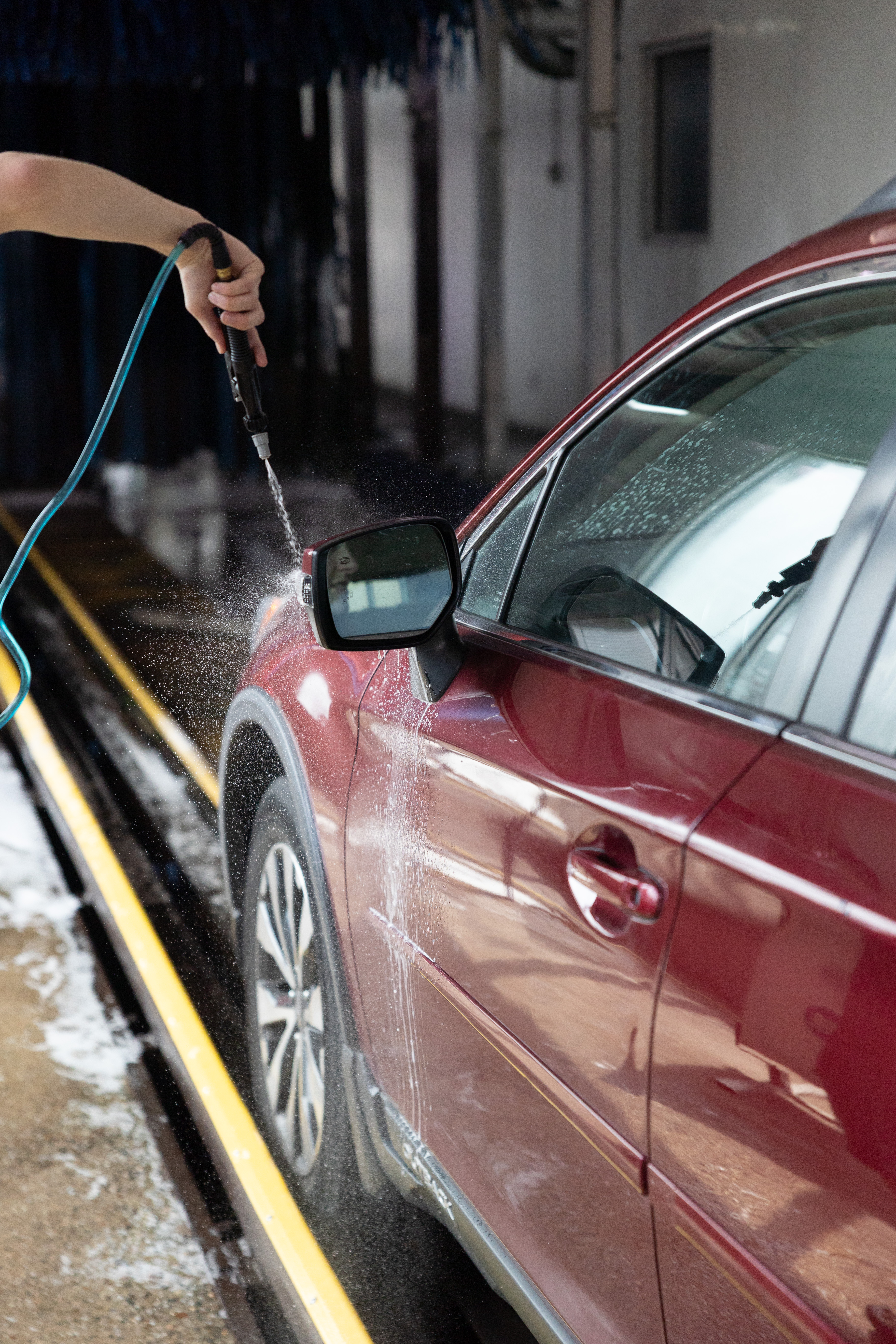 Pressure washer spraying a car mirror