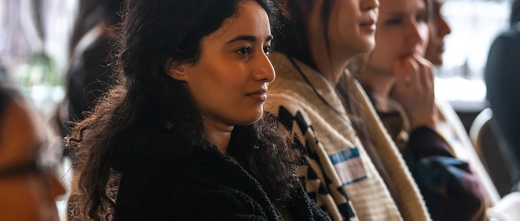 A woman listening intently at an Empower'em event