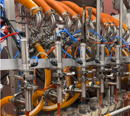 Filling heads dosing product into bottles