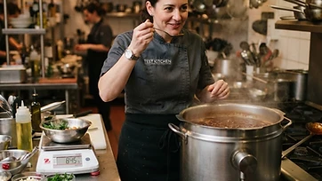 Chef tasting a sauce in a commercial test kitchen