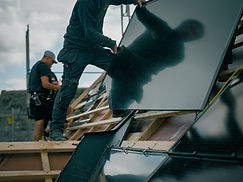 Montörer placerar en takintegrerad solpanel på taket