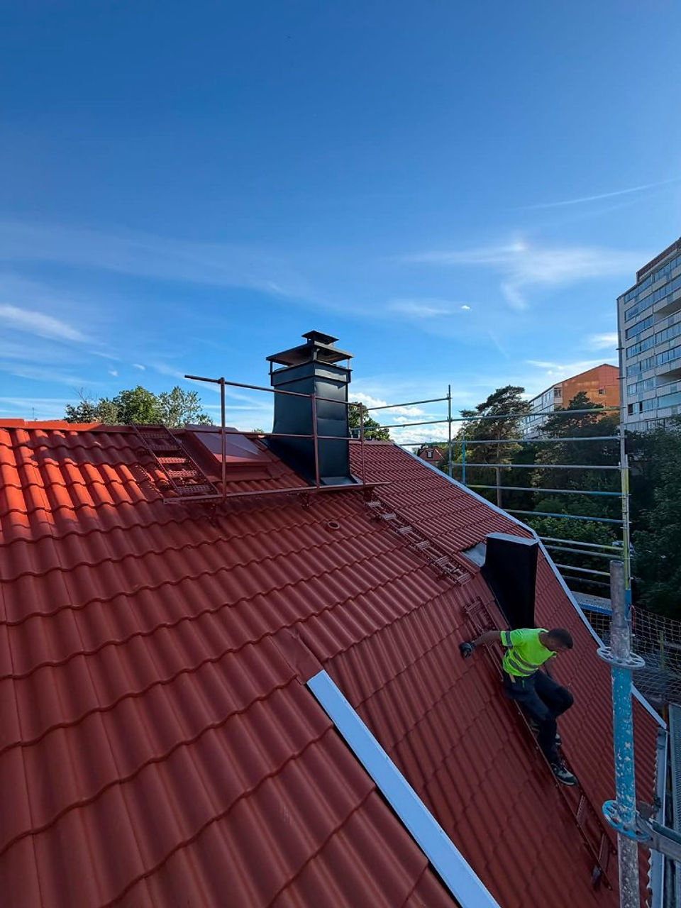 Takläggare monterar takpannor på ett hus i Lidingö