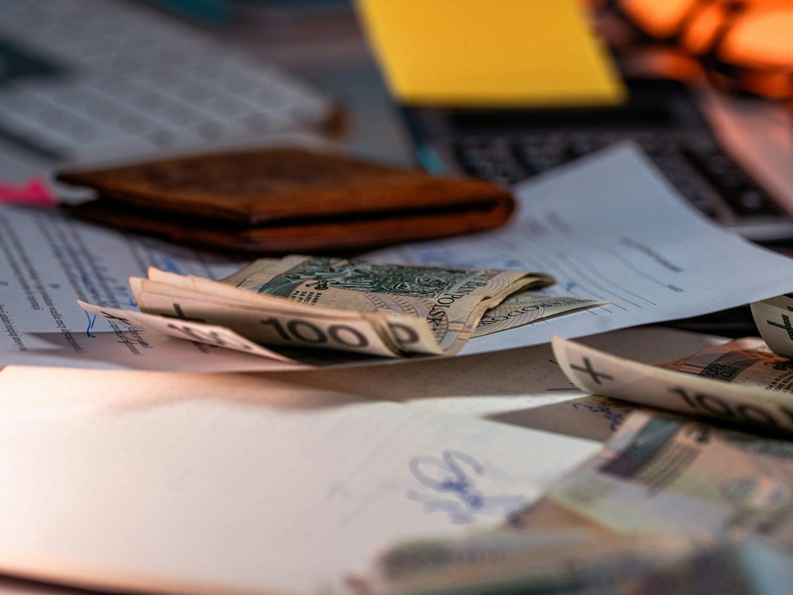 Worn wallet with cash and papers on a desk