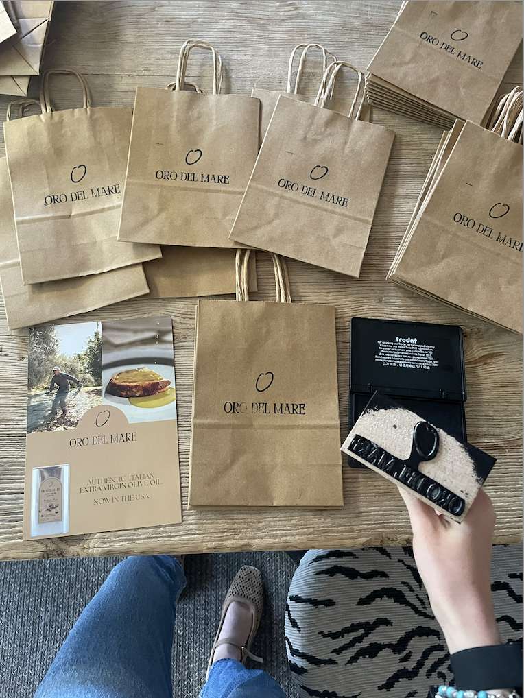 Oro del Mare branded bags, stamp, and promotional card
