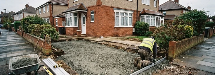Driveway groundwork with compacted sub-base and edging being set