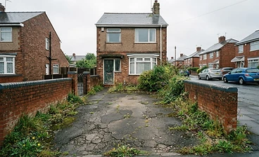 Cracked and tired tarmac driveway at a British home