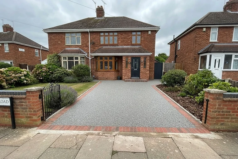 Finished silver-grey resin bound driveway in front of a Gloucester red-brick semi-detached house