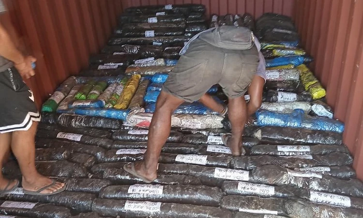 Interior of a shipping container holding recovered metal bars wrapped and labelled with OJDC inventory numbers and weights