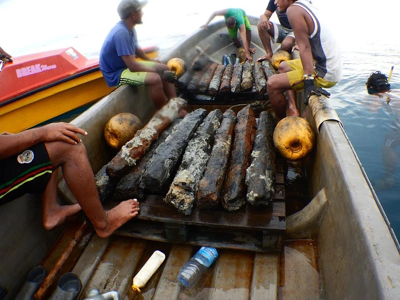 OJDC dive crew raising freshly recovered iron ingots aboard the work boat in the waters of the Ontong Java Atoll