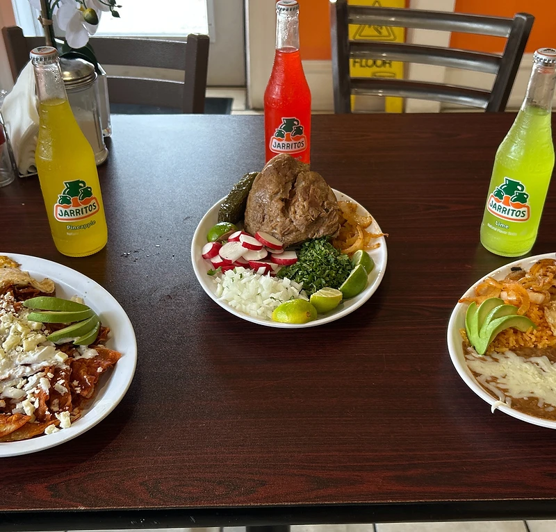 Inside El Alex Carnitas y Taqueria — hand-painted counter mural depicting carnitas, tortillas, and traditional Michoacán dishes