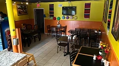 Dining room with yellow walls, balloons, and Mexican serapes