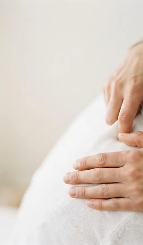 Therapist's hands performing a gentle corrective movement