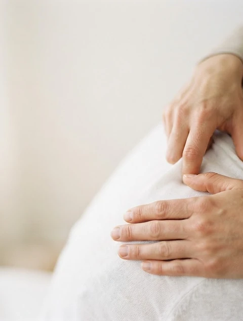 Therapist's hands performing a gentle corrective movement