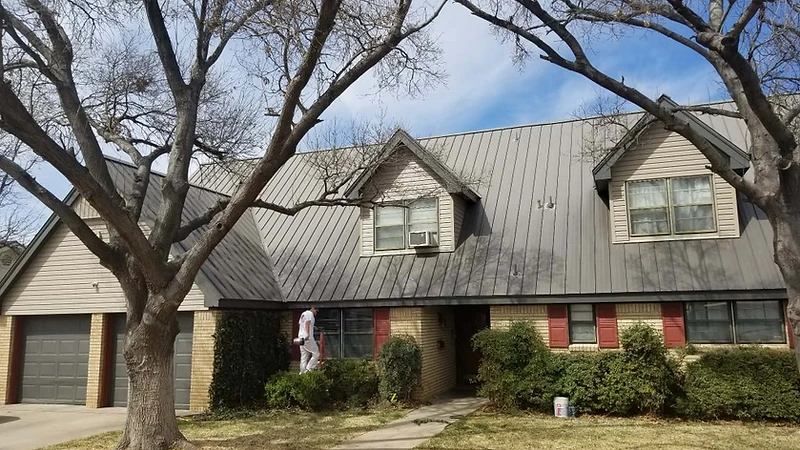 Painting crew preparing and painting a home exterior, residential exterior painting in progress
