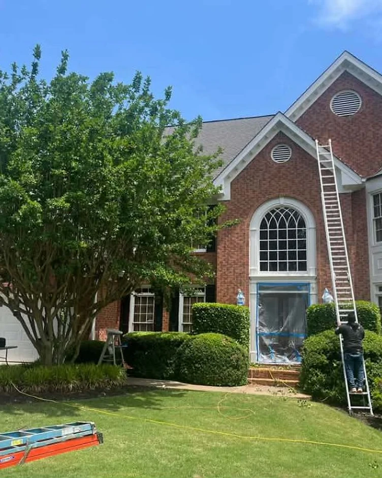 Home exterior with brick and siding during a painting project, residential exterior painting in progress