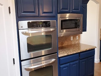 Navy blue kitchen cabinets with arched panel doors and new finish, cabinet painting and refinishing in Odessa, TX