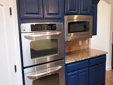 Navy blue kitchen cabinets with arched panel doors and new finish, cabinet painting and refinishing in Odessa, TX