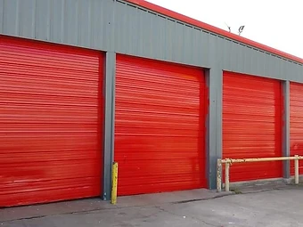 Commercial building with red bay doors and freshly painted exterior, commercial exterior painting in Odessa, TX