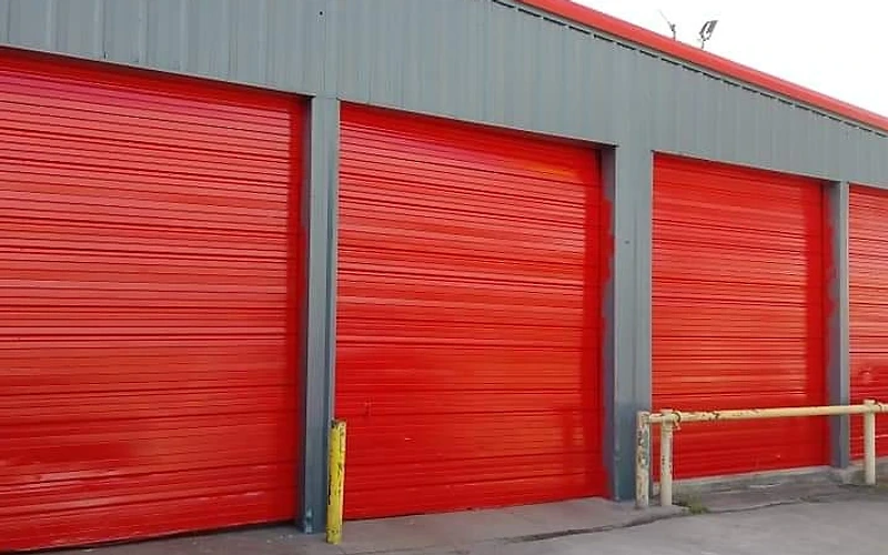 Commercial building with red bay doors and freshly painted exterior, commercial exterior painting