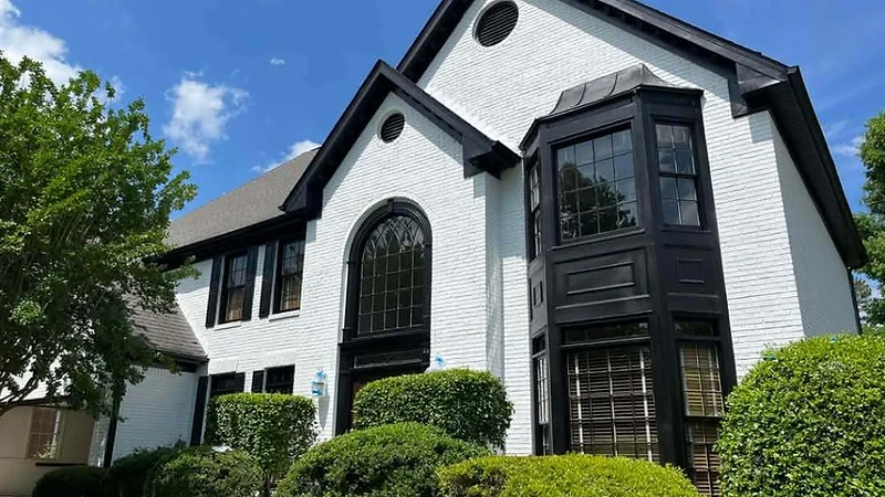 White brick home with black trim, finished residential exterior painting project