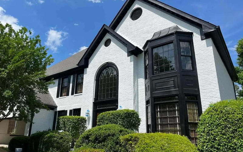 Two-story home with freshly painted white exterior and dark trim, residential exterior painting