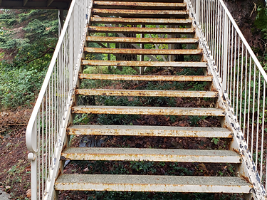 Before — rusted metal staircase prior to blasting