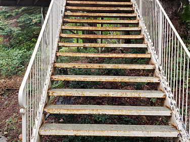 Before — rusted metal staircase prior to blasting
