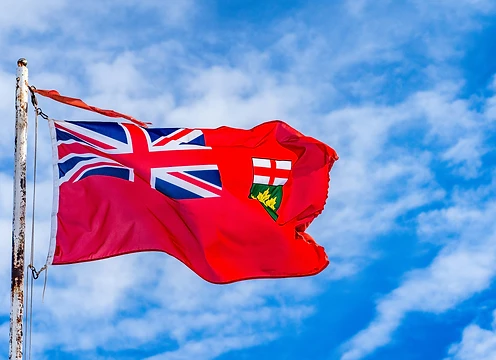 The Canadian Red Ensign flag flying against a bright sky