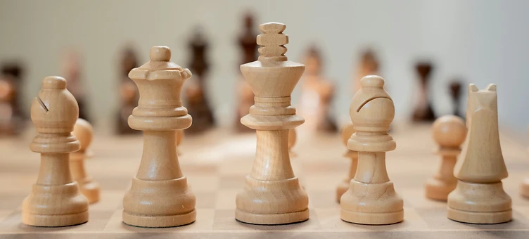 A wooden chess set on a board, symbolizing strategy and leadership