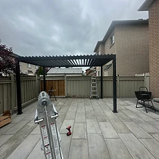 An assembled wooden pergola standing over a paved patio area.