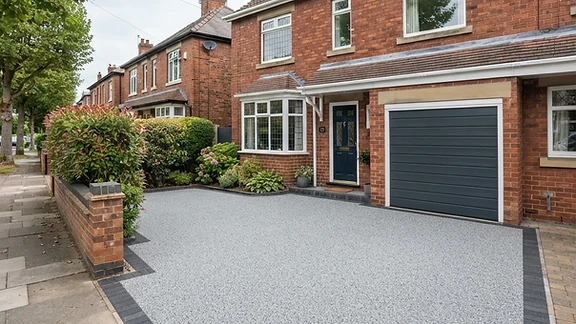 Freshly laid silver-grey resin-bound driveway in front of a red-brick semi-detached home in Chesterfield