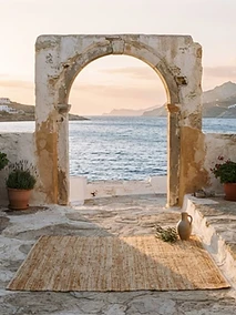 Terrasse méditerranéenne en pierre ouverte sur la mer au coucher du soleil