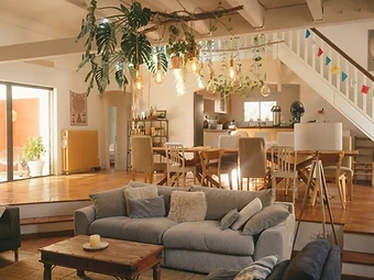 Le salon de la Villa Jema avec sa table basse, ses plantes suspendues et la lumière chaude du jour