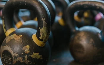 A row of kettlebells on a gym floor