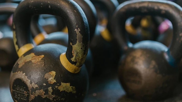 A row of kettlebells on a gym floor
