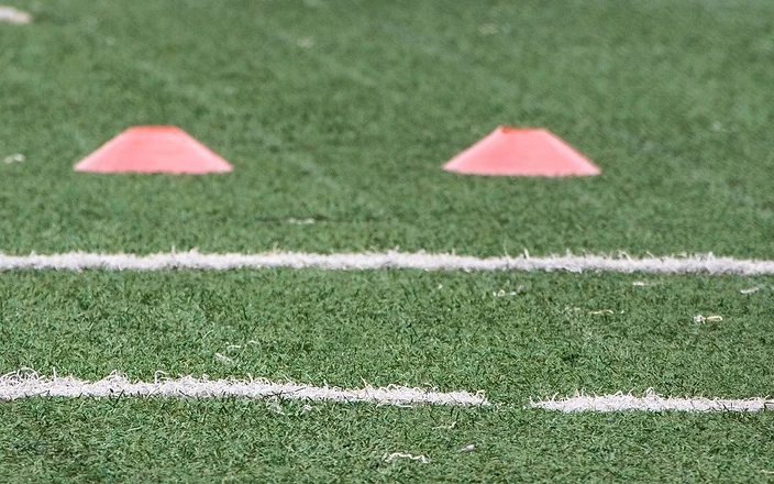 Training cones and a football on an artificial grass pitch