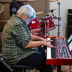 Keyboardist focused on the keys of a red Nord Stage 4