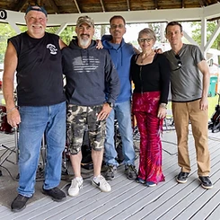 Over and Out posing together on the gazebo stage
